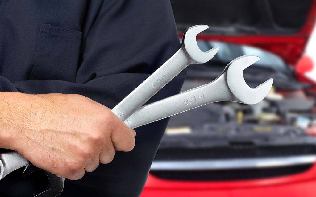 Person holding two wrenches