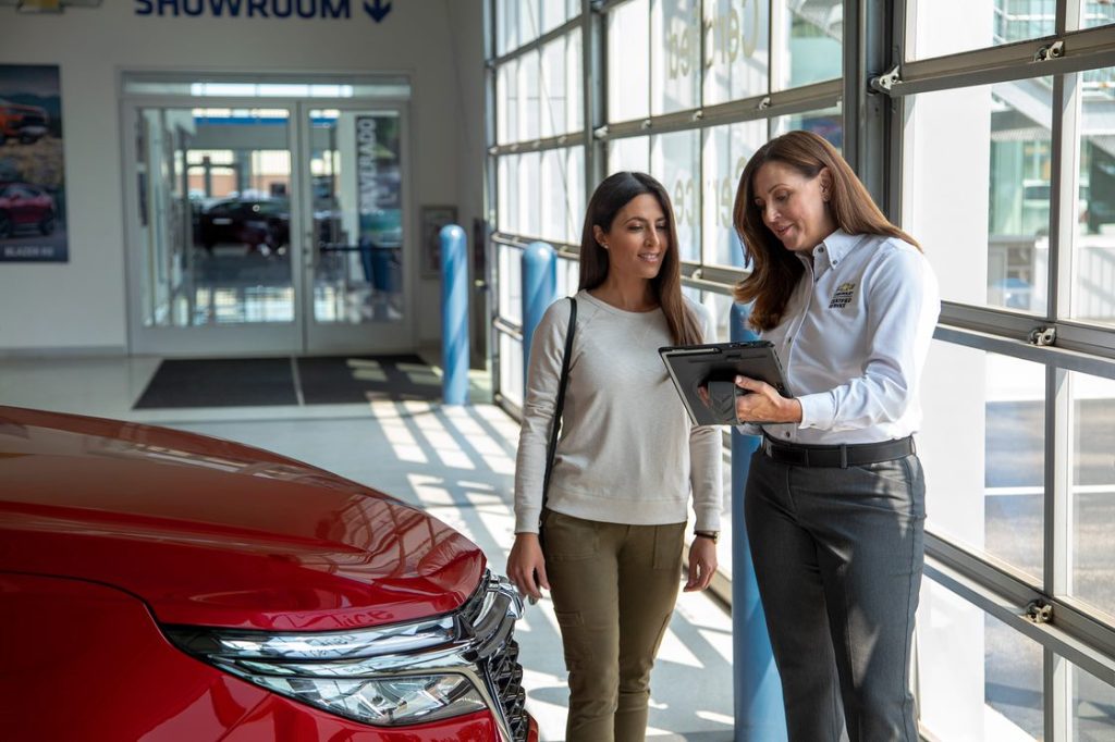 Women looking at a tablet in a car dealership