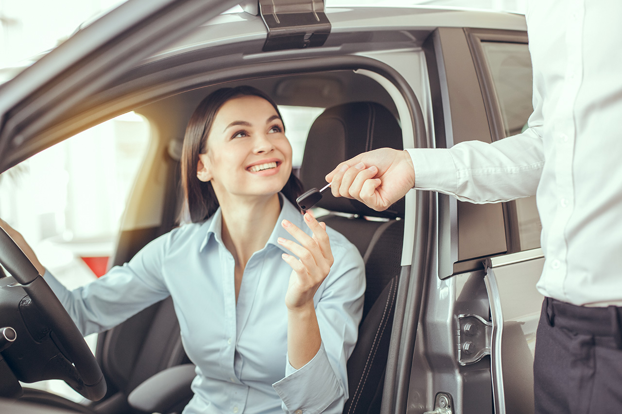 Young woman sitting in a car test drive rental service