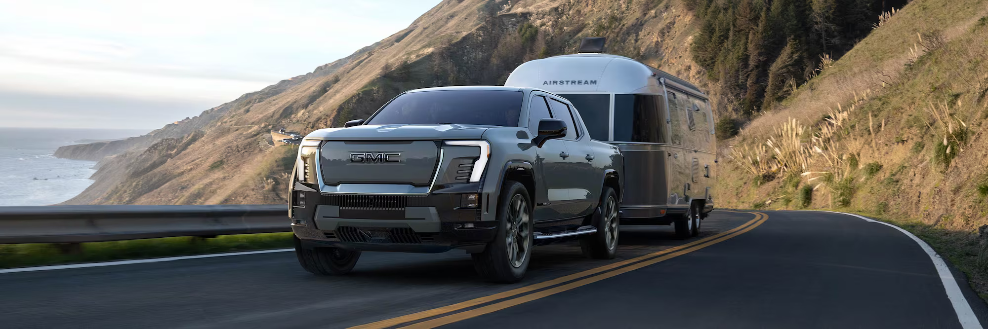 GMC Sierra EV towing camper driving on the highway